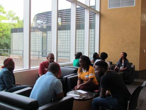 People sitting in groups of three or four have conversations